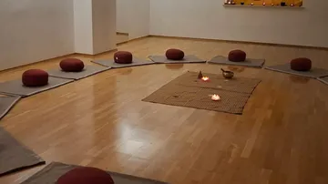 Meditation cushions arranged in a circle on floor.
