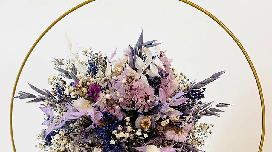 Bunte Trockenblumen im runden Rahmen.