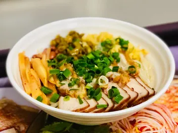 Schüssel mit Reis, Fleisch und frischem Gemüse dekoriert.