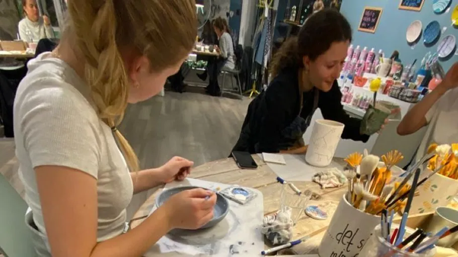 Zwei Frauen bemalen Keramik im Studio.
