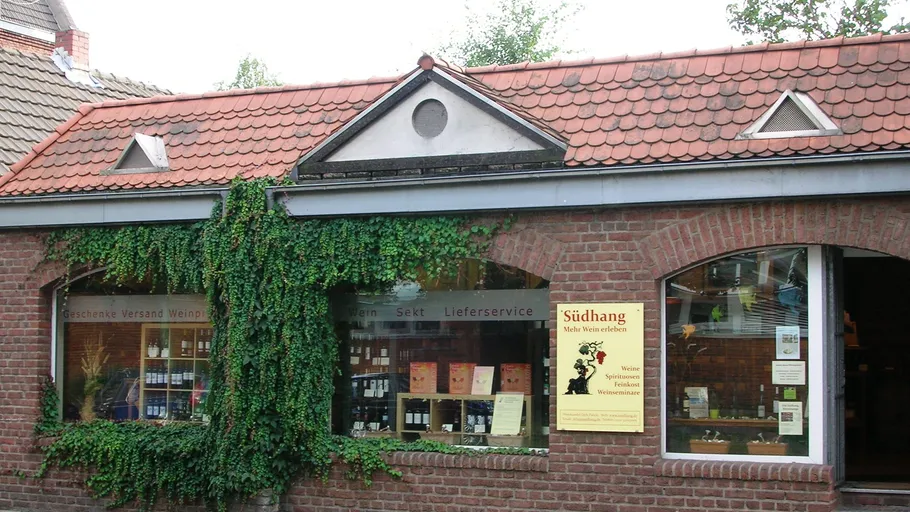 Brick wine shop with ivy and red roof.