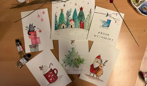 Handmade Christmas cards displayed on wooden table.