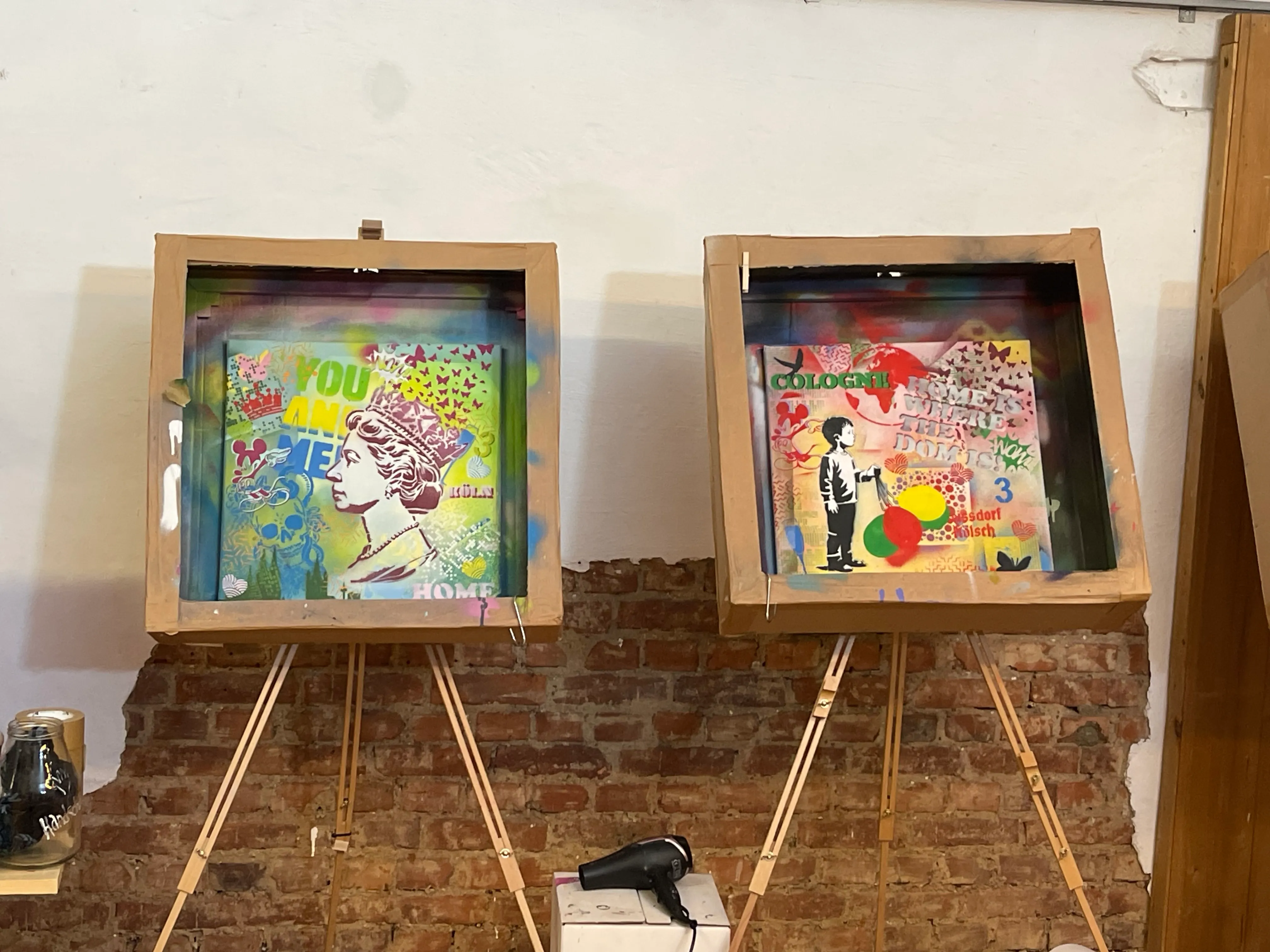 Zwei bunte Gemälde auf Staffeleien, Ziegelwand Hintergrund.