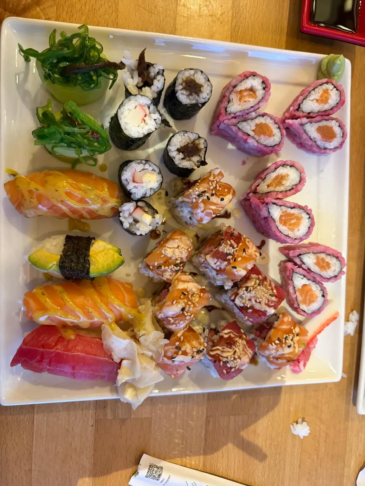 Verschiedene Sushi-Rollen auf einem weißen Teller.