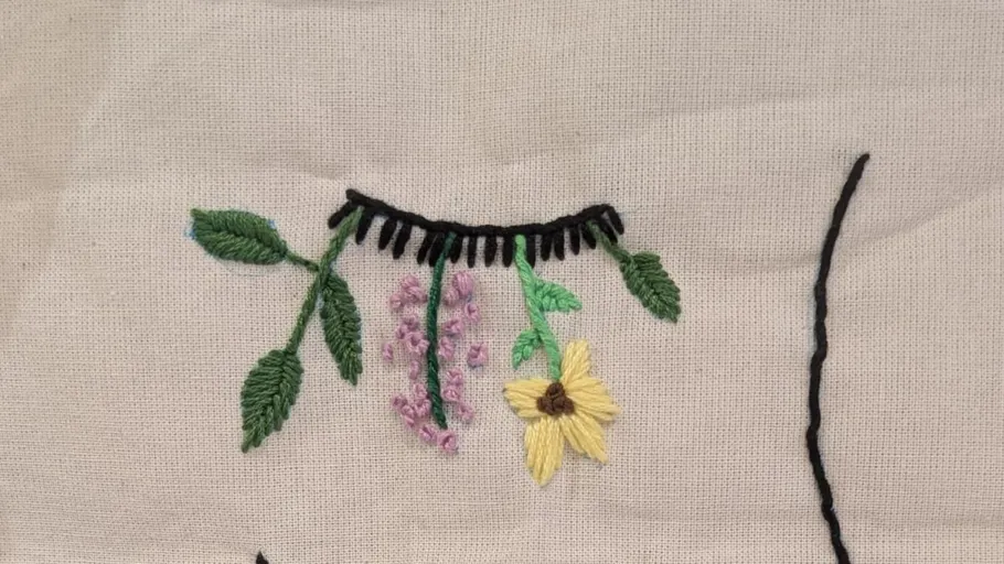 Embroidery of leaves and flowers on fabric.