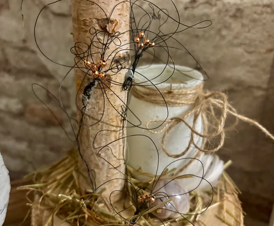 Drahtblumen an Birkenbaum mit Kerze.