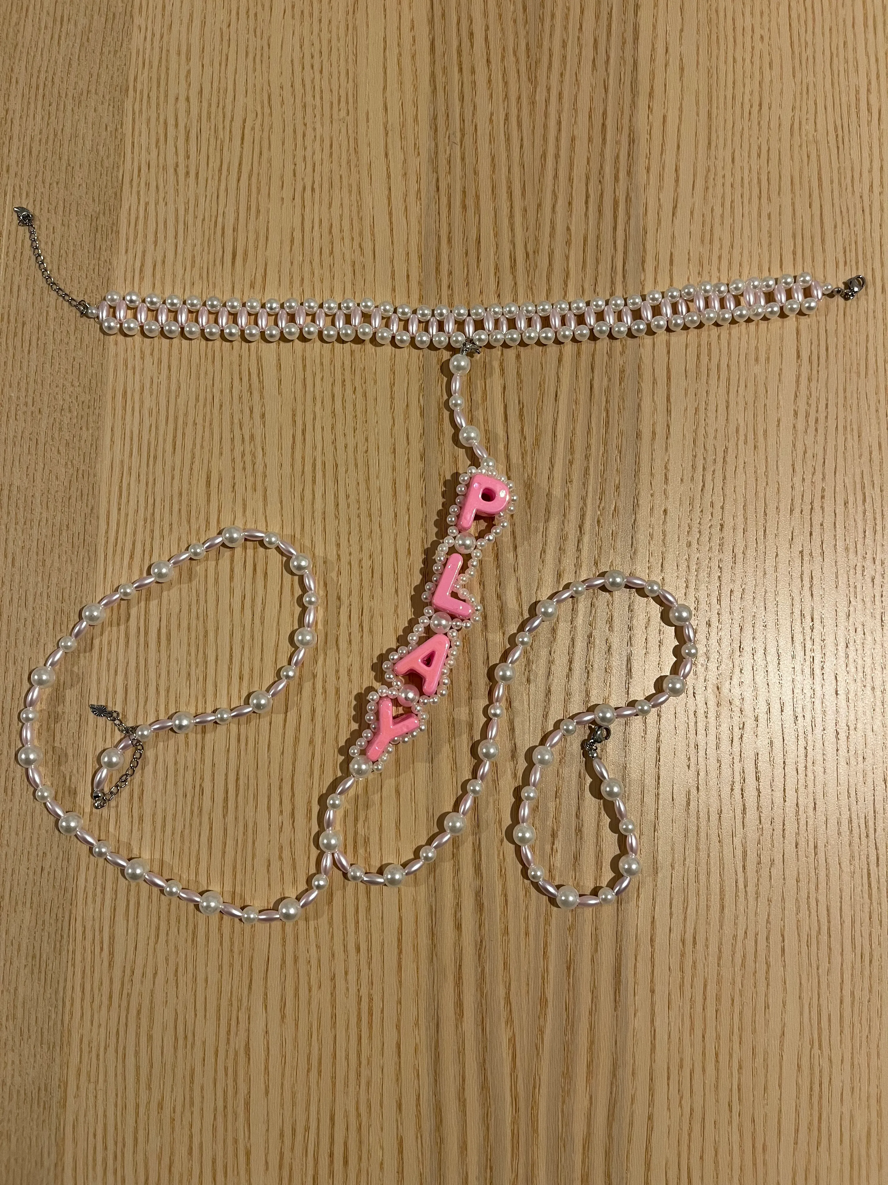 Perlenkette und Choker auf Holztisch.