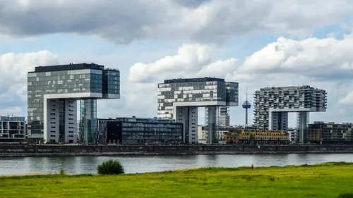 Modern crane-like buildings along a river.