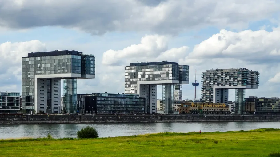 Modern crane-like buildings along a river.