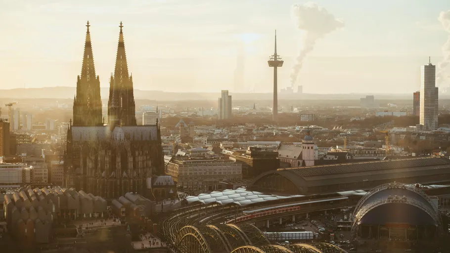 Cologne Cathedral with city skyline at sunset.