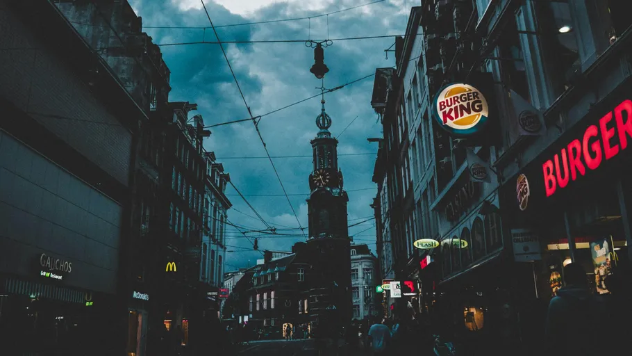 City street with shops and a tower.
