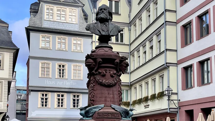 Bust of Friedrich Stoltze in urban square.