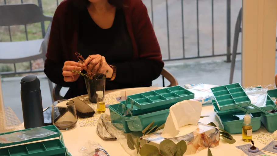 Person arranging flowers at a table indoors.