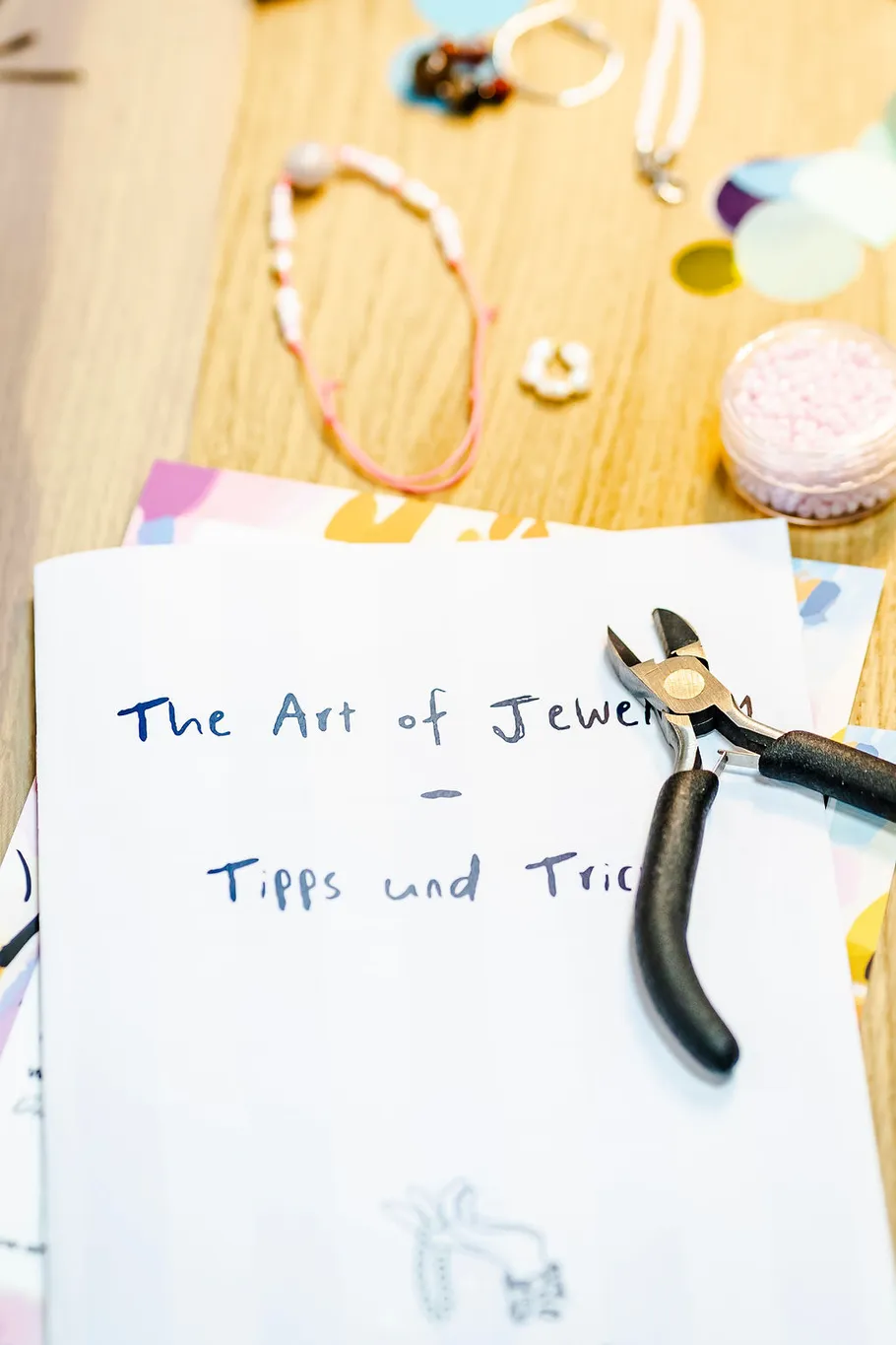 Jewelry tools, guidebook on wooden table.