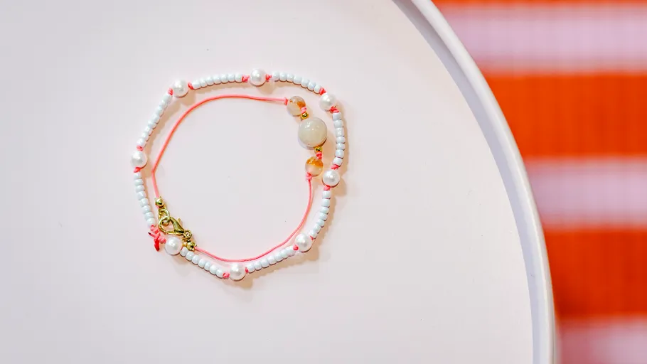 Beaded bracelet on a white round surface.