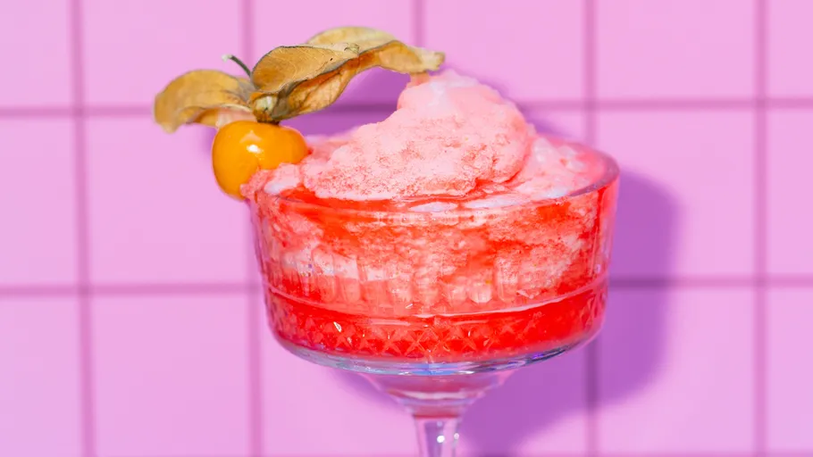 Rosa Cocktail mit Fruchtgarnitur, gefliester Hintergrund.