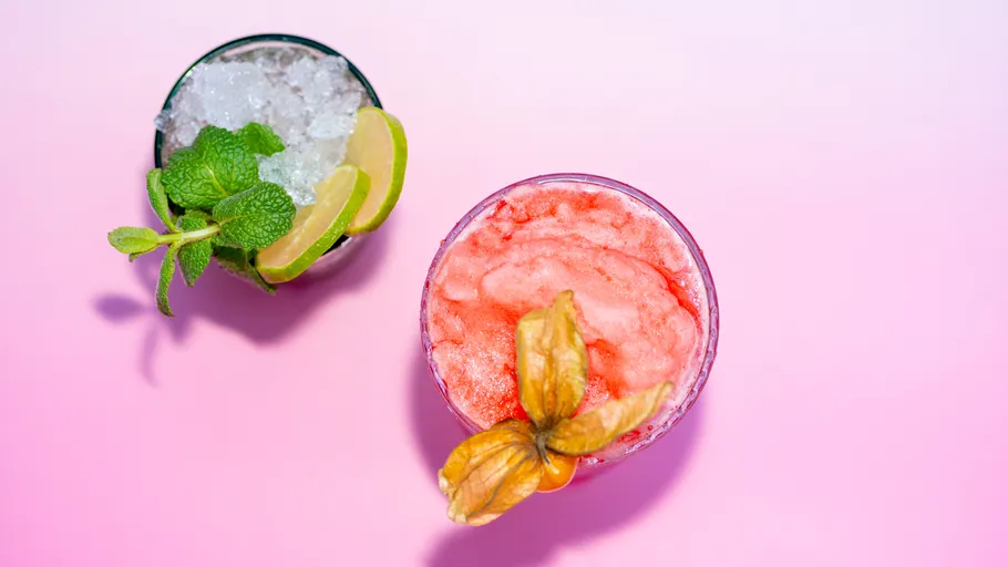 Zwei Cocktails auf rosa Hintergrund.