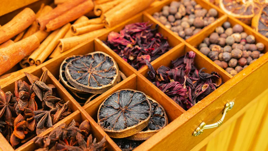 Verschiedene getrocknete Gewürze in Holzkiste sortiert.