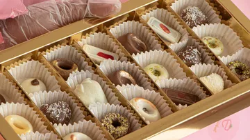 Verschiedene Pralinen in einer goldenen Schachtel.
