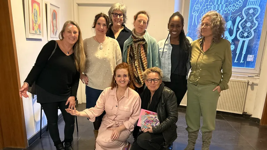 Group of women posing indoors, smiling.