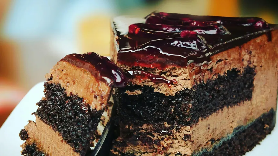 Chocolate cake slice with cherry topping.