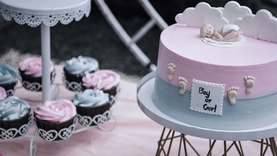 Cake with baby decoration, gender reveal theme.