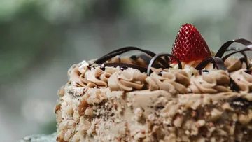Cake with chocolate frosting and strawberry topping.