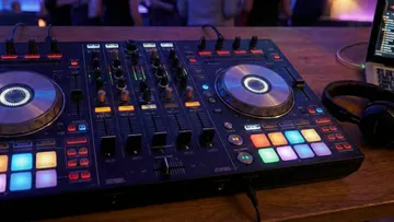 DJ controller with colorful lights on table.