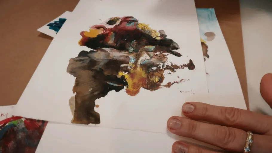 Person hält abstraktes Gemälde auf Papier.