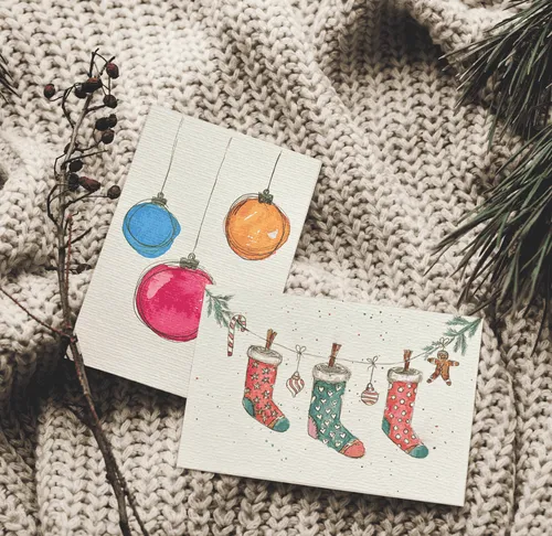 Christmas cards on knit fabric with twigs.