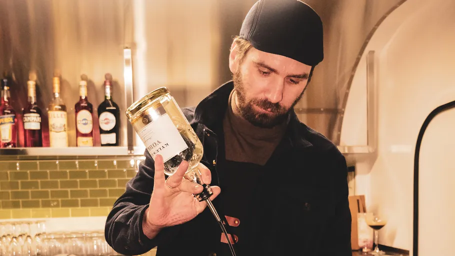 Man pouring whiskey in a bar setting.