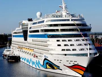 A cruise ship is in port and is being loaded.