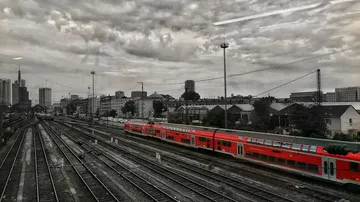 Passagierzug fährt durch städtische Gleise.