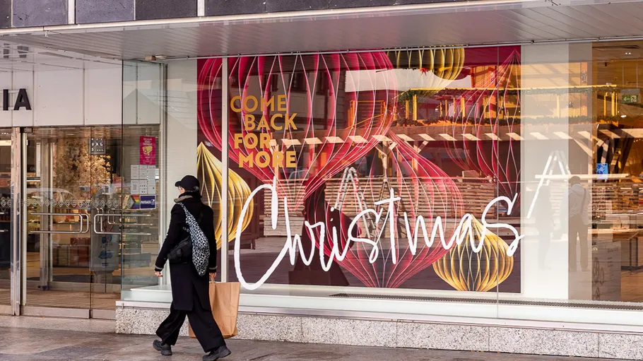 Person walking by Christmas window display.