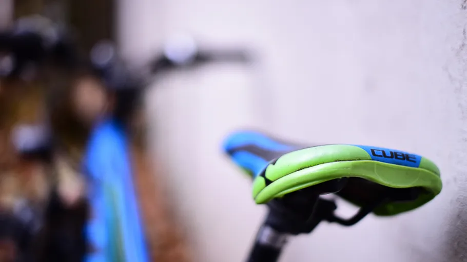 Close-up of a green and blue bike seat.