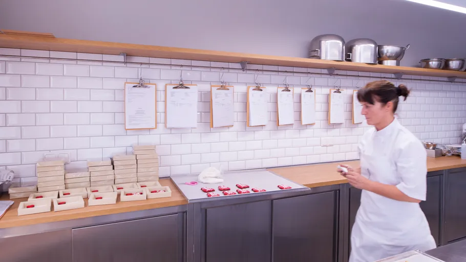 Woman packaging chocolates in a kitchen.