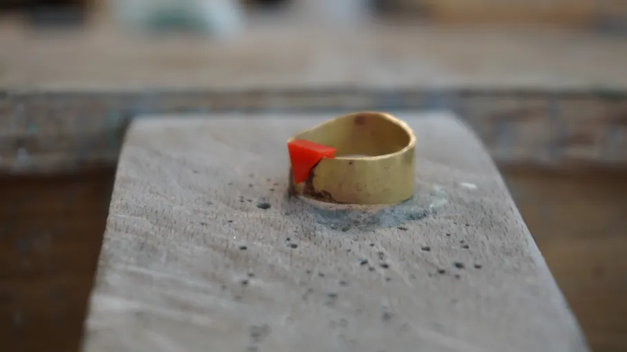 Ring with red detail on wooden surface.