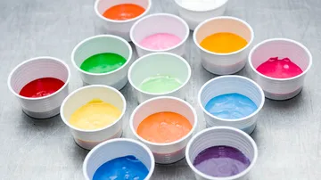 Colorful cake batter in white cups.