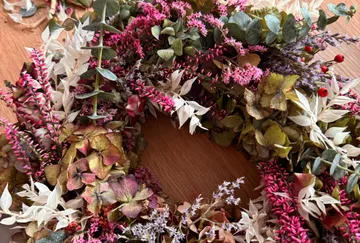 Colorful floral wreath on wooden table.