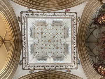 Church ceiling with ornate decorations and windows.