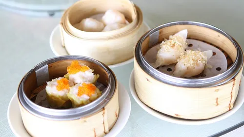 Dim sum baskets with dumplings on table.