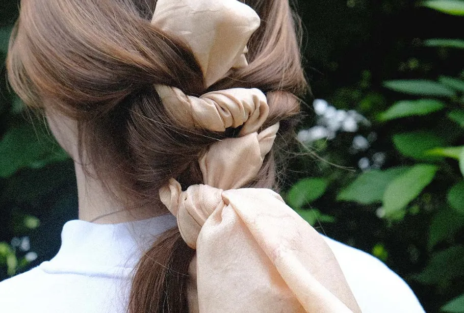 Haar mit Band geflochten draußen.