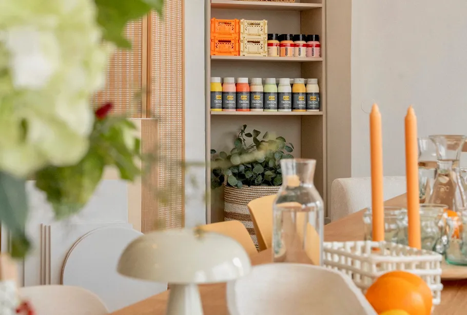 Cozy dining area with candles and shelf.