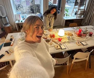 Zwei Frauen posieren im festlichen Esszimmer.