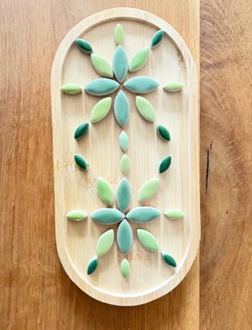 Leaf design on wooden tray surface.