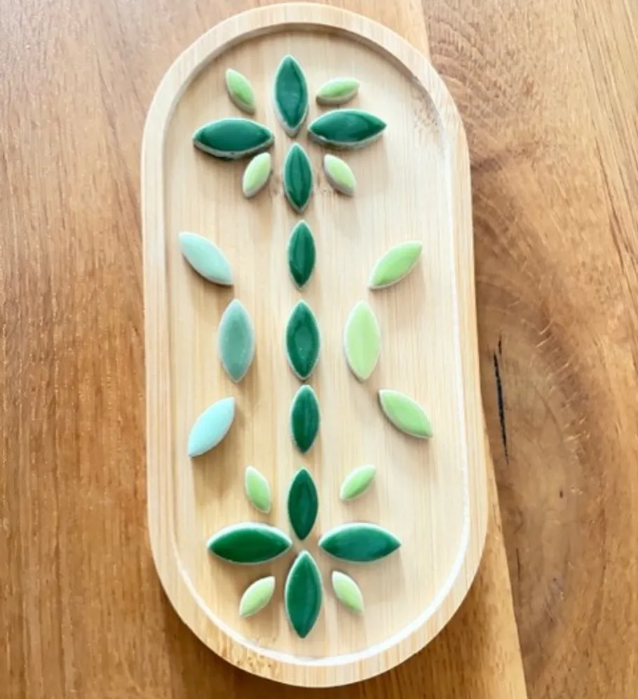 Green ceramic leaves on wooden tray.