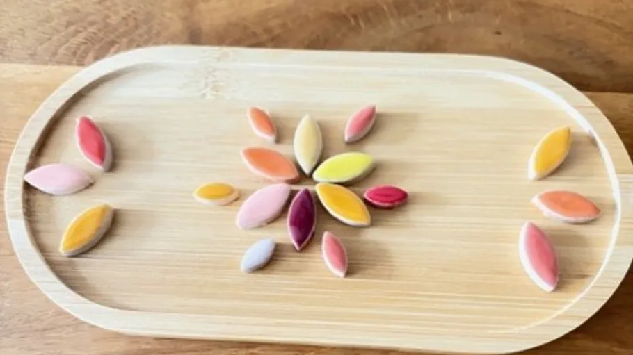Colorful oval candies arranged on a wooden tray.