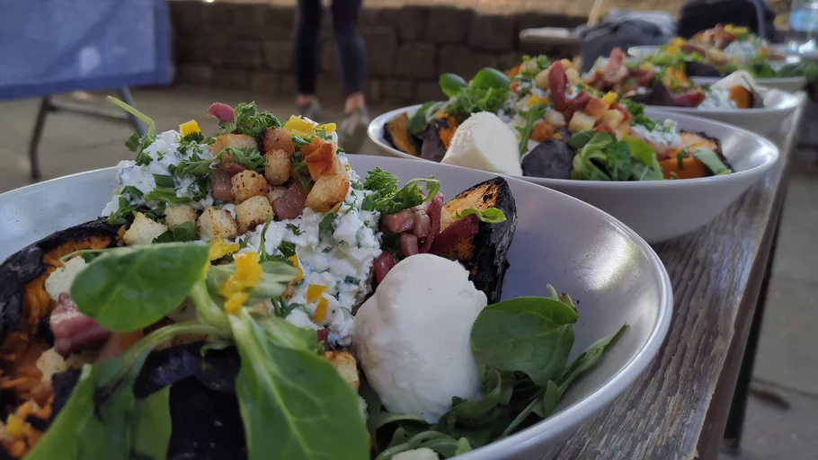Colorful salads in white bowls on a table.