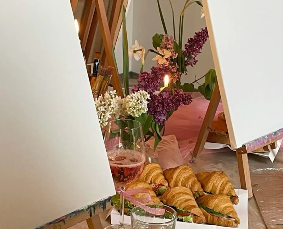 Kunststaffeleien mit Croissants und Blumen arrangiert.