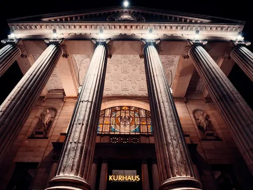 Classic building with pillars, illuminated at night.